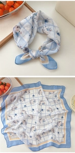 Detail of cotton linen scarf featuring hedgehog pattern and blue floral checkered print