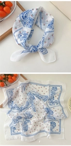 Detail of blue paisley and cherry print cotton linen scarf with soft knotted texture