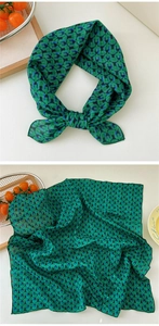 Detail of green geometric pattern silk scarf with elegant knots and natural textures