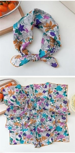Detail of printed cotton linen square scarf with vibrant floral patterns and orange edges