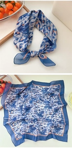 Detail of blue leopard print cotton scarf with orange trim shown in a lifestyle setting