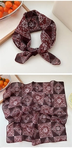 Detail of burgundy cotton linen scarf with bohemian floral patterns and hemmed edges