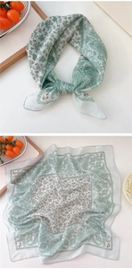 Detail of light green paisley pattern chiffon scarf with delicate hemmed edges
