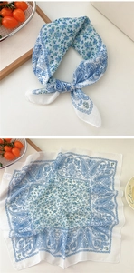 Detailed close-up of blue and white paisley pattern cotton linen square scarf on a tray