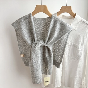 Detail of grey wool knit shawl with hollow wavy texture over white shirt