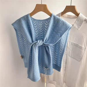 Close-up of light blue hollow-out knit shawl featuring V-pattern texture and tie detail