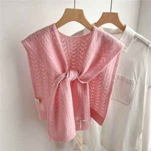 Detail view of pink wool knit shawl with delicate V-shaped hollow pattern and brand tag