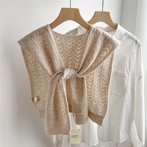 Detail showing beige 100% wool knit shawl with V-shaped hollow pattern and soft texture