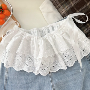Detail of white floral lace collar with embroidery and silk ribbons on denim fabric