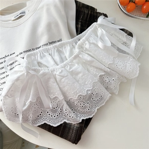 Detail of white lace tiered cuffs with floral embroidery and satin ribbon bow ties