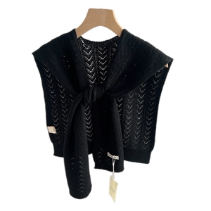 Black knitted wool shawl wrap with hollow crochet pattern and front knot on white background