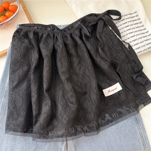 Close-up of black floral lace mini skirt layer with bow ribbon and brand label detail
