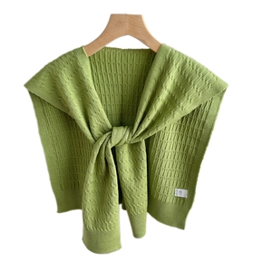 Scialle a maglia verde erba con motivo a treccia su una gruccia in legno