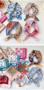 Detail view of assorted cotton linen floral scarves with vintage patterns and branded tags
