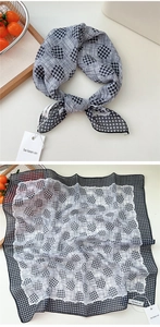 Detail of black and white checkered cotton linen scarf showing texture and hem edges