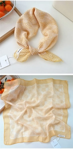 Detailed view of yellow plaid cotton linen scarf with breathable texture and woven label