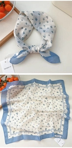 Detail of floral cotton linen square scarf showing blue flower pattern on white fabric