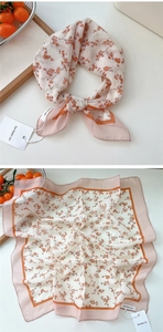 Detail of floral print cotton-linen square scarf with beige background and soft texture