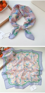 Detail of square silk scarf with peach pattern, purple borders and brand tag detail