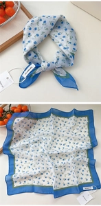 Detail of floral linen square scarf with blue blossoms and delicate green border design