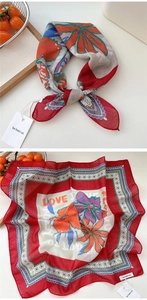 Detail of red floral cotton linen square scarf with artistic text and brand tag