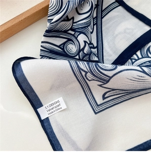 Détail d'un foulard en velours imprimé montrant des coutures fines et des motifs baroques