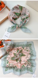 Detailed close-up of a floral cotton linen scarf with soft pink and green patterns