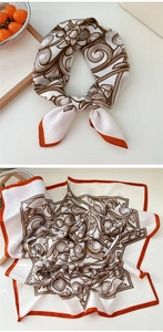 Détail d'un foulard carré en coton et lin avec motifs vintage marron et bordures orange vif