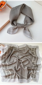 Détail du foulard gris en coton et lin avec motifs de chaînes blanches et texture du tissu
