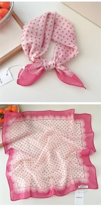 Macro detail of polka dot silk scarf with lace edges and ribbon patterns on light fabric