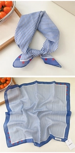Detail of blue striped square scarf with red polka dots and soft cotton-linen texture