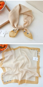 Detail of yellow striped square scarf with blue polka dots and soft texture