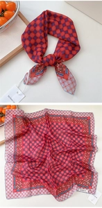Detailed close-up of red polka dot cotton scarf with vintage floral border and soft texture