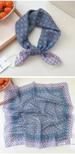 Detailed view of floral silk scarf with blue patterns and branded be keen on tag