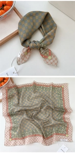 Detailed view of sage green and brown plaid square scarf with floral borders and soft texture