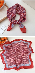 Close-up of a red and blue polka dot silk scarf featuring cute cartoon figure patterns