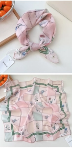 Detail of pink and green checkered silk scarf featuring floral print and fine edge stitching
