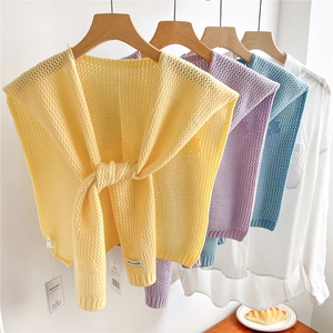 Hollow knit flower shawls in yellow, purple and blue displayed on white shirts