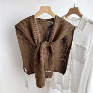 Detailed knit texture of dark brown crochet shawl accessory over a white shirt