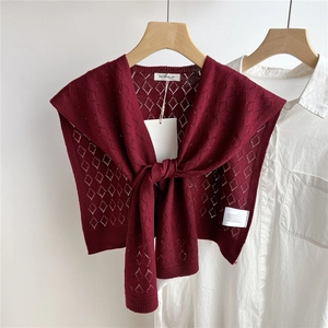 Detail des weinroten Strickschals mit Rautenmuster und geknotetem Front-Design