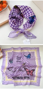 Dettaglio di foulard in seta a scacchi viola con farfalle colorate e bordi ondulati
