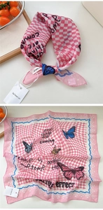 Dettaglio del foulard in seta a quadri rosa con farfalle colorate e scritte motivazionali