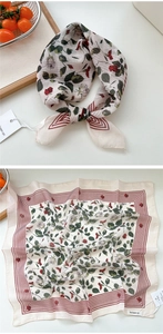 Dettaglio di un foulard quadrato con stampe a rose rosse e bordo a righe su vassoio