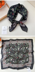 Dettaglio di foulard quadrato con rose rosse e bordi a righe su sfondo beige chiaro