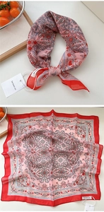 Vista piatta di un foulard di seta vintage con motivi paisley rosa e targhette di marca