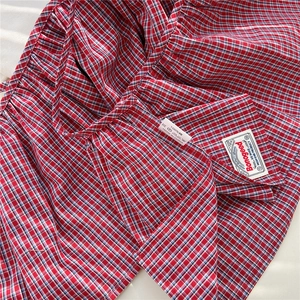 Detailed macro view of 100% cotton fabric weave and inner brand label on plaid skirt