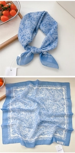 Dettaglio del foulard in seta blu con motivi paisley e leopardati e trama fine