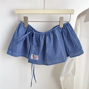 Detail of blue and white gingham decorative skirt layer with drawstring and brand label