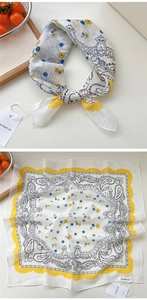 Dettaglio di un foulard quadrato con stampa paisley, bordi smerlati gialli e trama in cotone