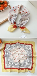 Dettaglio di un foulard di seta quadrato con motivo paisley, bordo giallo e onde rosse
